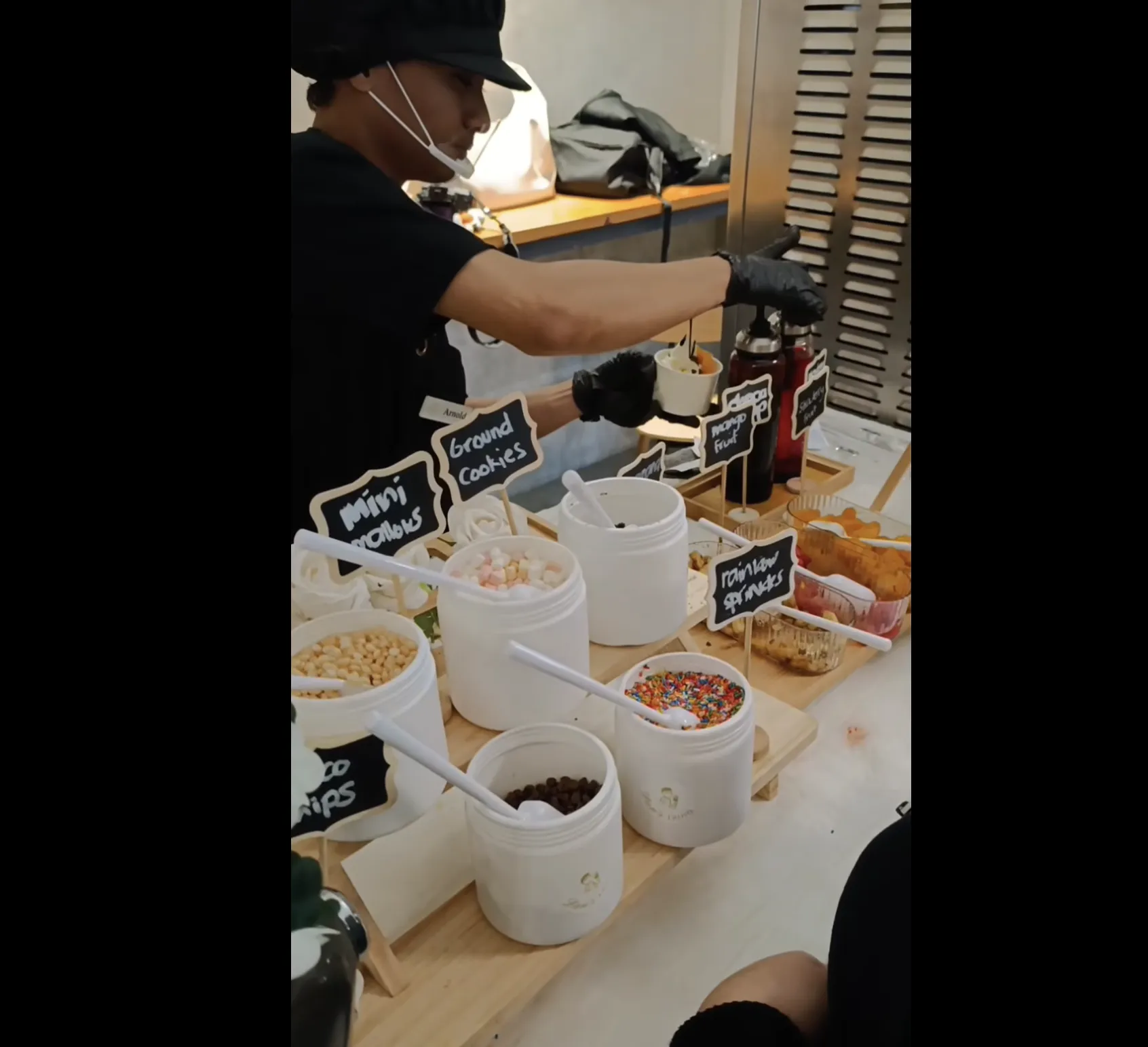 Guest building a custom froyo cup at the toppings bar